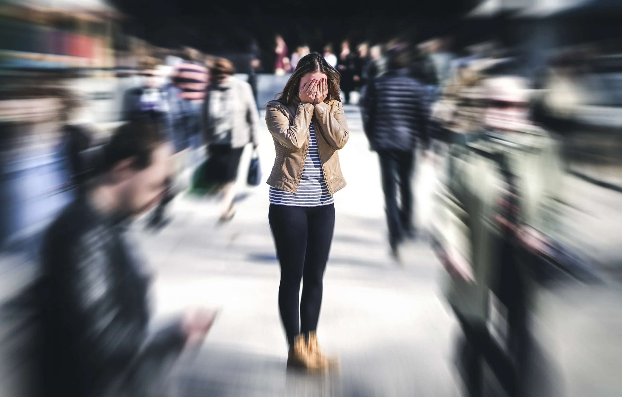 A woman standing overwhelmed in a busy crowd, representing the anxiety and isolation of untreated depression and mood disorders requiring advanced psychiatric care at Georgia Behavioral Health